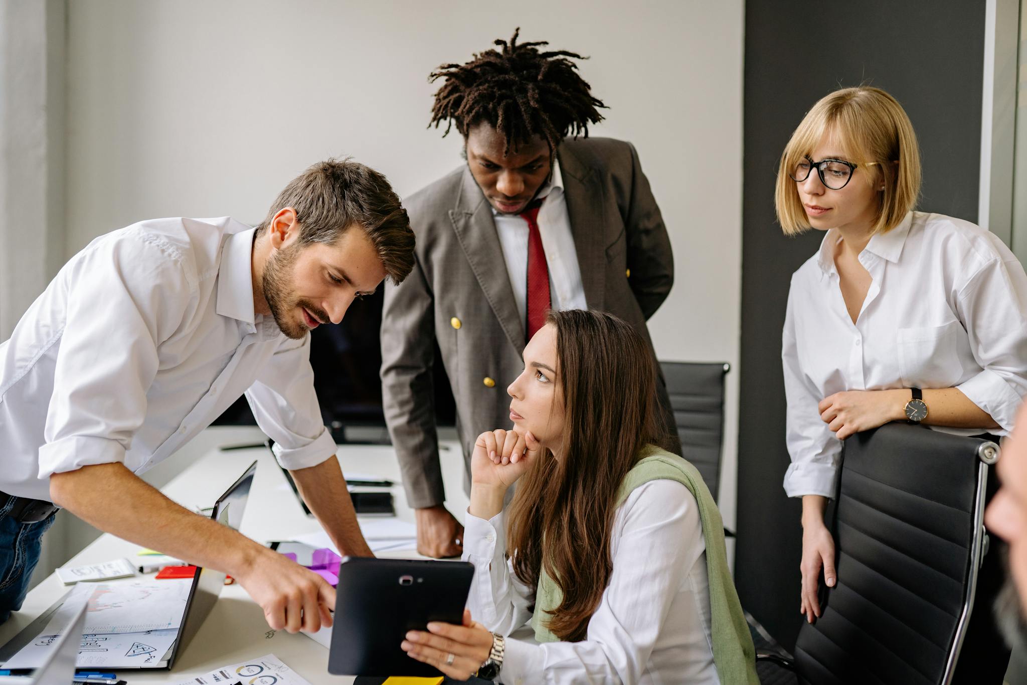 A group of professionals engaging in a collaborative business meeting in a modern office.